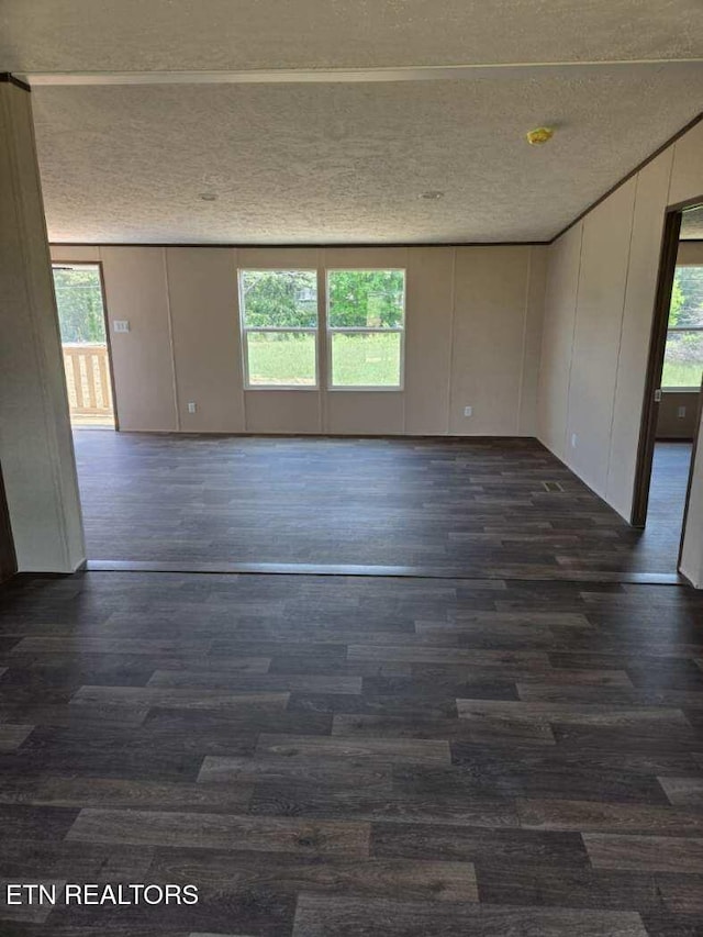unfurnished room featuring dark wood finished floors and a textured ceiling