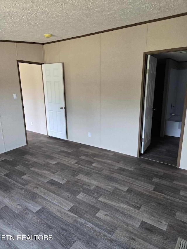 unfurnished bedroom with crown molding, a textured ceiling, and wood finished floors