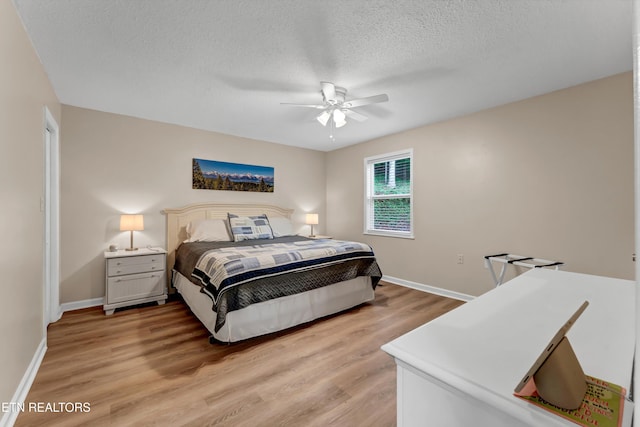 bedroom with baseboards, ceiling fan, light wood-style floors, and a textured ceiling