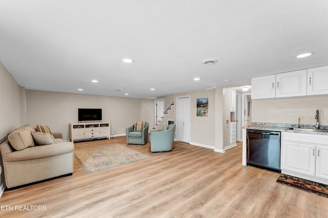 living area with stairway, baseboards, light wood-type flooring, recessed lighting, and wet bar