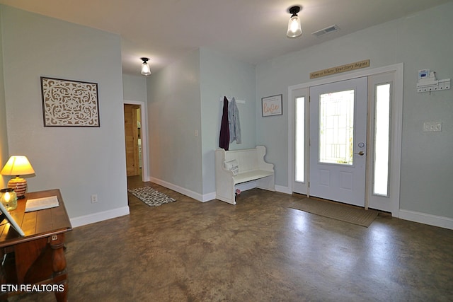 foyer featuring baseboards, visible vents, and finished concrete floors