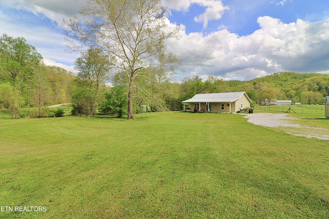 view of yard with gravel driveway and fence