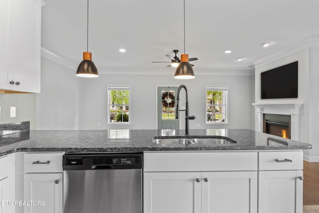 101 Fortenberry St, Oak Ridge, TN 37830 - kitchen with stainless steel dishwasher, a warm lit fireplace, dark stone counters, a sink, and white cabinetry
