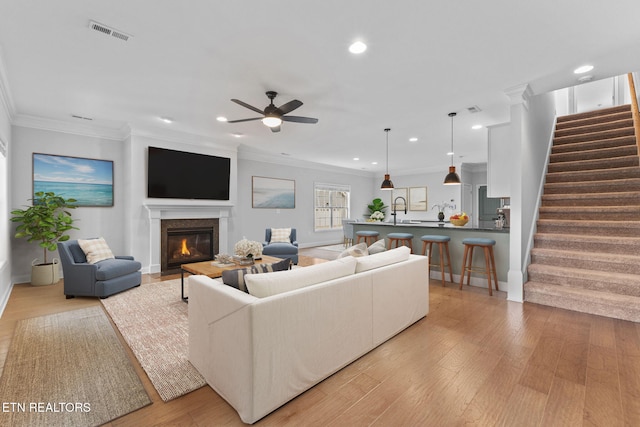 101 Fortenberry St, Oak Ridge, TN 37830 - living area with crown molding, visible vents, light wood-type flooring, a ceiling fan, and stairs