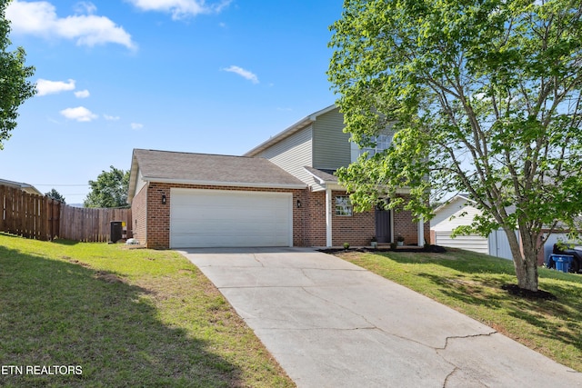 view of front of home with fence, a front lawn, brick siding, and a garage