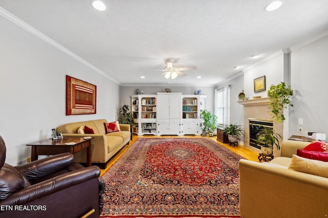 living room featuring wood finished floors, a ceiling fan, ornamental molding, and recessed lighting
