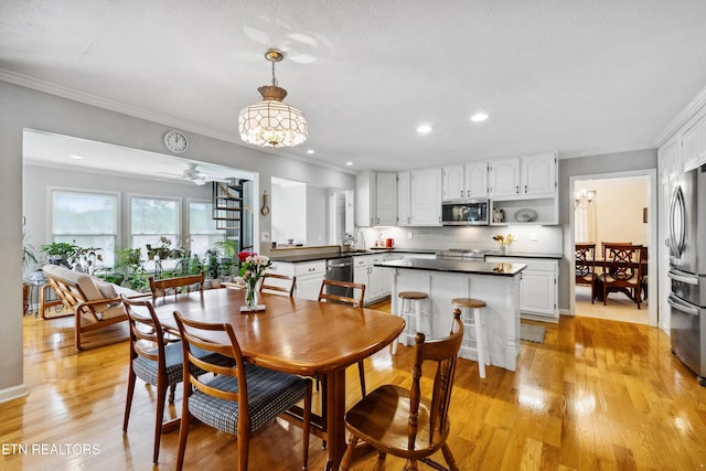 dining room with crown molding, light wood finished floors, recessed lighting, and ceiling fan with notable chandelier