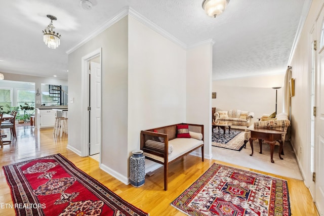 hallway with ornamental molding, light wood finished floors, and baseboards