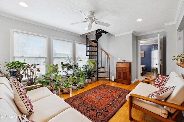 living area with recessed lighting, light wood-style floors, ceiling fan, stairway, and crown molding