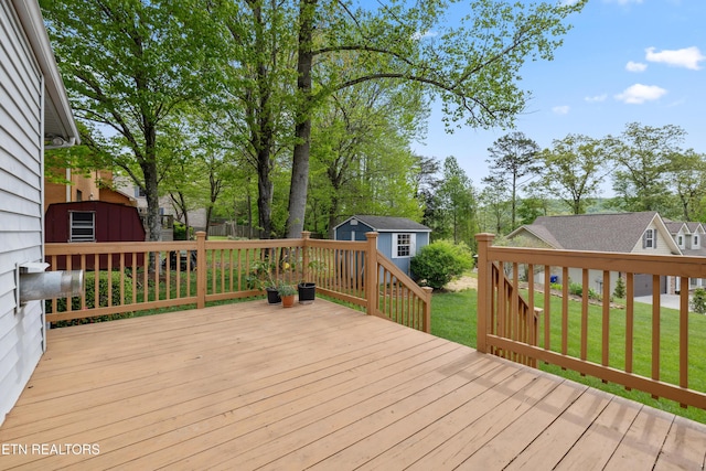 deck featuring an outbuilding, a yard, and a residential view
