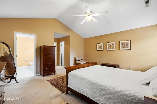 bedroom featuring lofted ceiling, light colored carpet, visible vents, baseboards, and ensuite bath