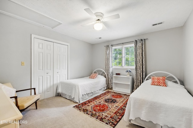 bedroom with visible vents, a ceiling fan, carpet flooring, and a closet