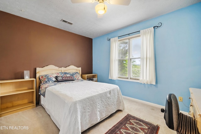 bedroom featuring ceiling fan, carpet flooring, baseboards, visible vents, and a textured ceiling