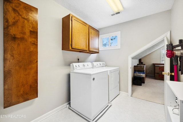 laundry area with visible vents, washer and clothes dryer, cabinet space, and baseboards
