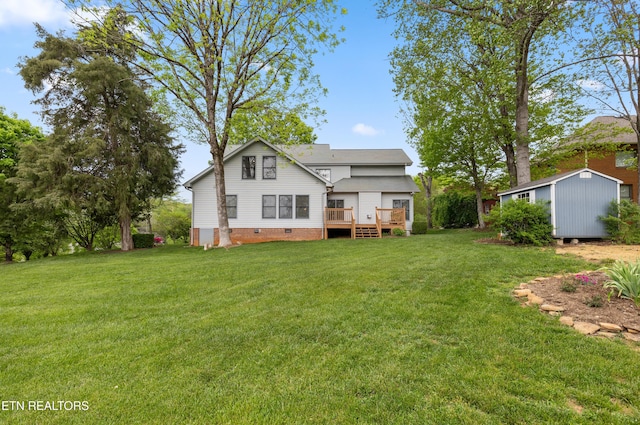 rear view of property featuring a wooden deck, crawl space, an outbuilding, a lawn, and a storage unit