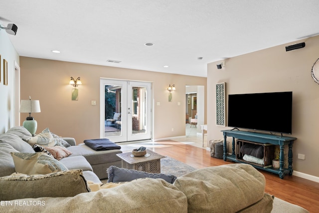 living area featuring baseboards, recessed lighting, wood finished floors, and french doors