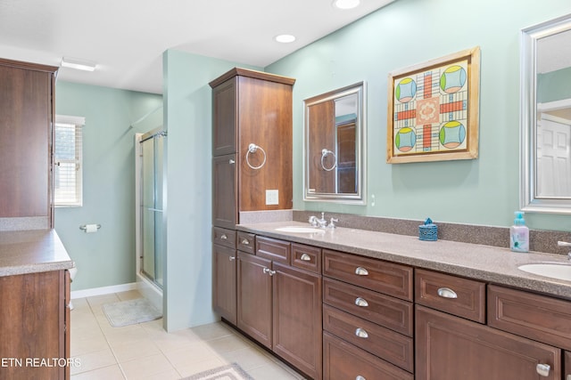 full bath with double vanity, a stall shower, tile patterned flooring, and a sink
