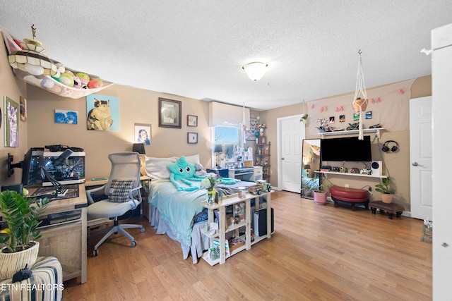 bedroom featuring a textured ceiling and wood finished floors