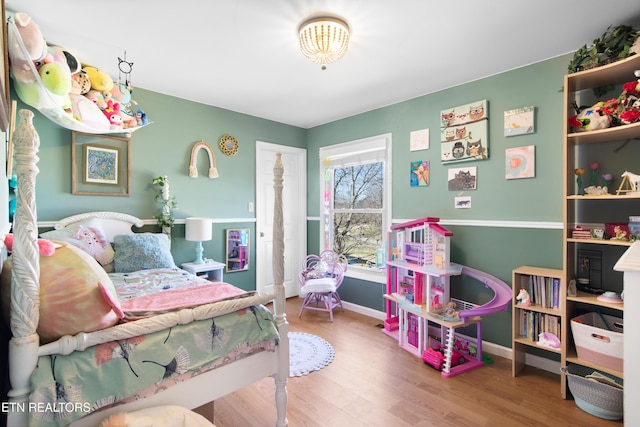 bedroom featuring baseboards and wood finished floors