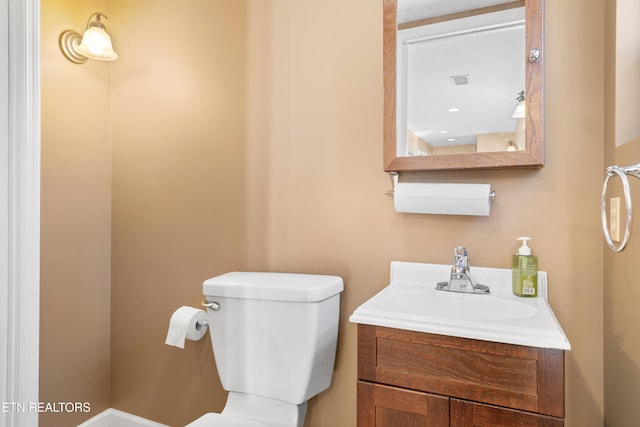 half bathroom featuring vanity and toilet