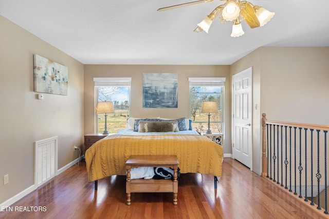 bedroom featuring wood finished floors, visible vents, and multiple windows