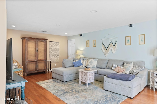 living room featuring recessed lighting, visible vents, and wood finished floors