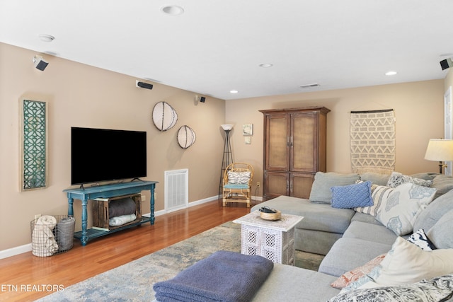 living room with baseboards, visible vents, wood finished floors, and recessed lighting