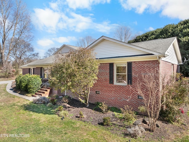 ranch-style home featuring a front yard, roof with shingles, crawl space, and brick siding