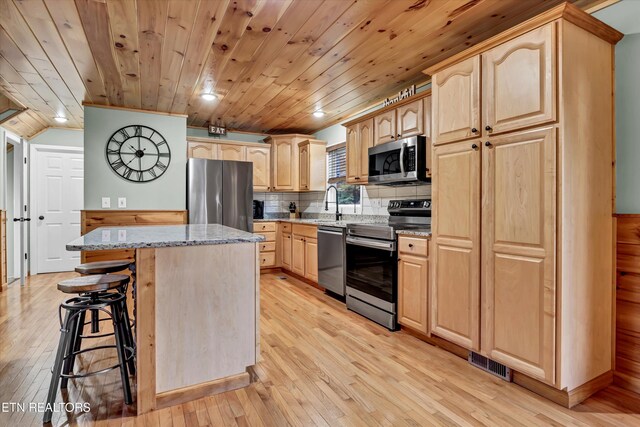 3131 Valley Home Rd, Sevierville, TN 37862 - kitchen featuring appliances with stainless steel finishes, light brown cabinetry, light stone countertops, a center island, and light wood-style floors