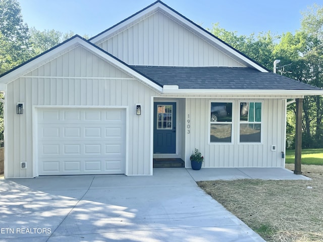 view of front facade featuring a garage, covered porch, driveway, board and batten siding, and roof with shingles