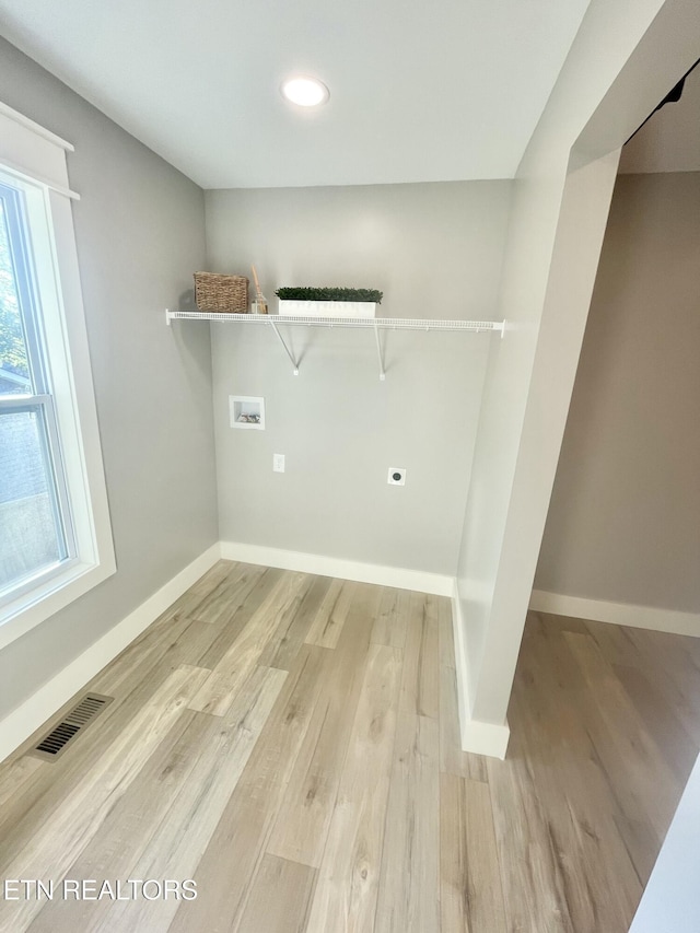 laundry room with visible vents, baseboards, hookup for a washing machine, light wood-type flooring, and laundry area