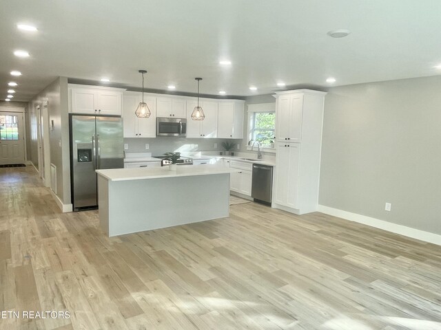 kitchen featuring recessed lighting, a sink, white cabinetry, light countertops, and appliances with stainless steel finishes