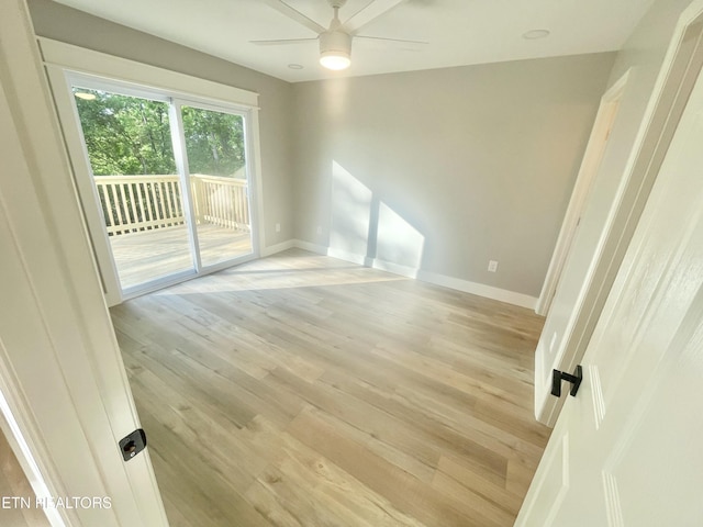 spare room featuring ceiling fan, baseboards, and light wood-style floors
