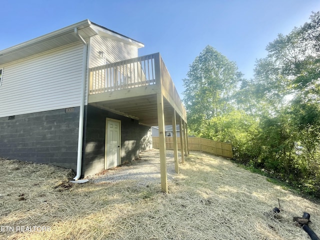 view of home's exterior featuring a wooden deck and fence
