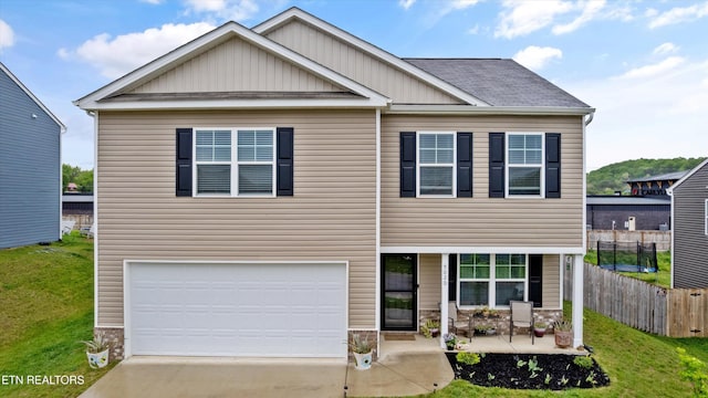 craftsman-style home featuring fence, a front yard, board and batten siding, concrete driveway, and an attached garage