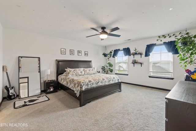 bedroom featuring baseboards, visible vents, ceiling fan, and light colored carpet