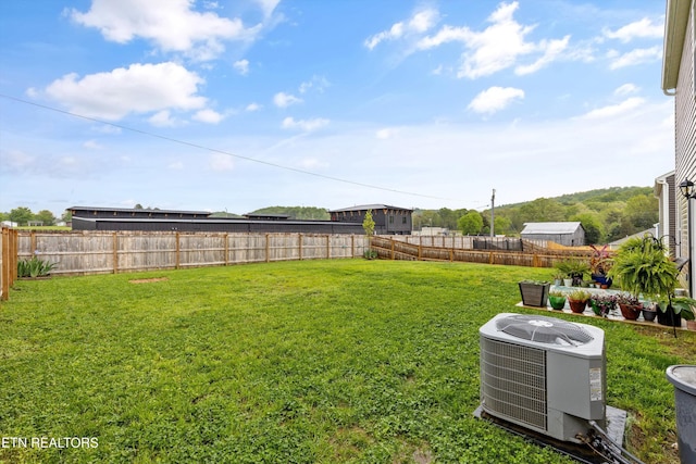 view of yard with a fenced backyard and central AC