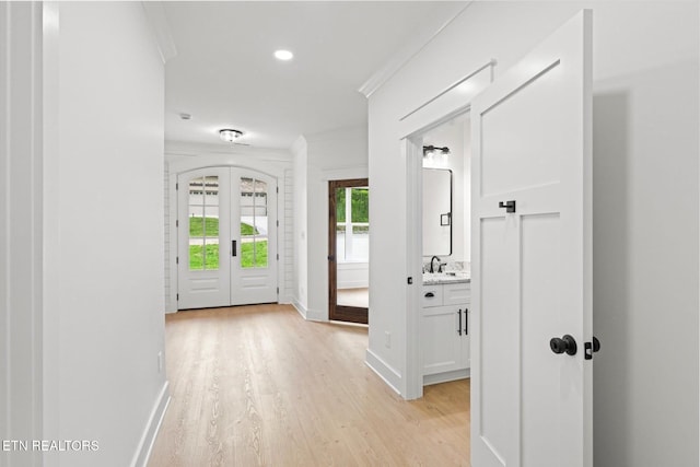 foyer entrance with crown molding, baseboards, recessed lighting, french doors, and light wood-style flooring