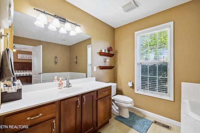 full bathroom with vanity, toilet, baseboards, visible vents, and a garden tub