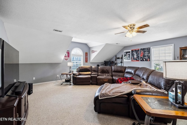 living room featuring a textured ceiling, carpet, a ceiling fan, lofted ceiling, and visible vents
