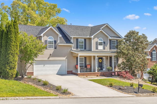 view of front of house with a porch, an attached garage, roof with shingles, and concrete driveway