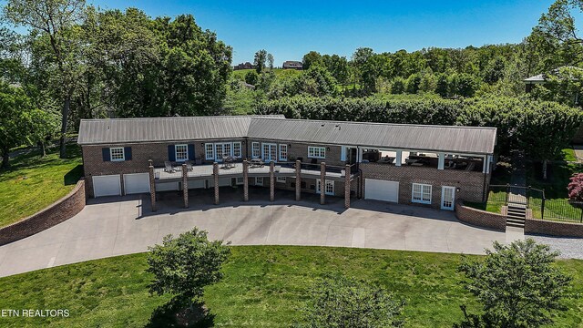 view of front of home with metal roof, a front lawn, and driveway