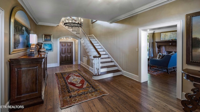 entrance foyer with wood finished floors, crown molding, stairs, and baseboards