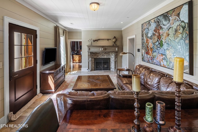 living area featuring ornamental molding, wooden walls, and a fireplace with flush hearth