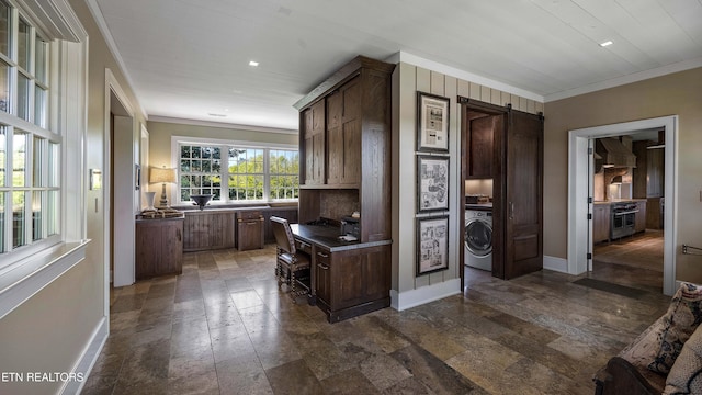 interior space with crown molding, stone finish floor, washer / clothes dryer, and baseboards