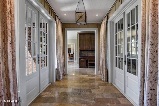 hall featuring recessed lighting, stone finish flooring, french doors, and plenty of natural light