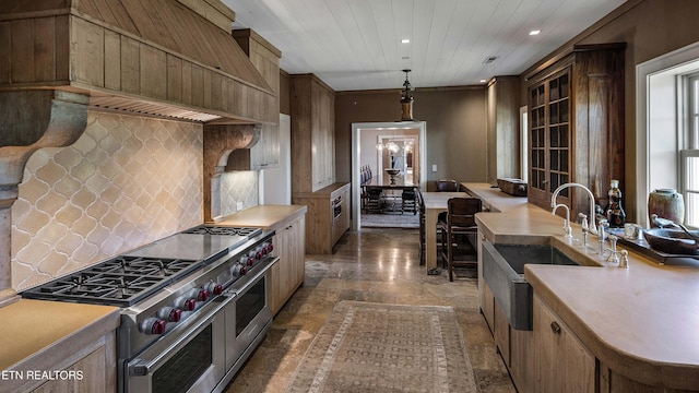 kitchen with recessed lighting, stone tile floors, range with two ovens, backsplash, and hanging light fixtures