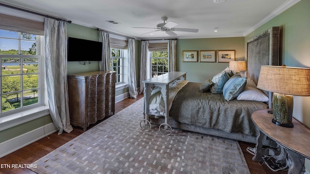 bedroom with wood finished floors, ornamental molding, ceiling fan, baseboards, and visible vents