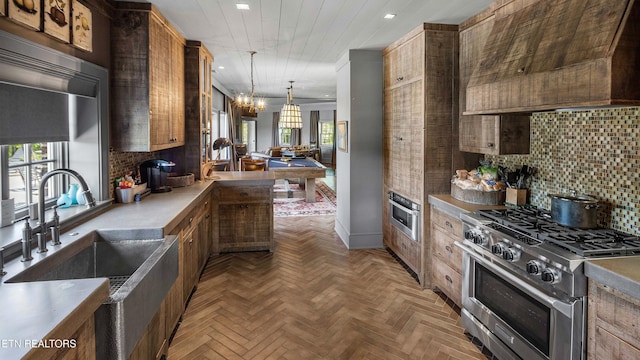 kitchen featuring recessed lighting, a sink, backsplash, premium range hood, and appliances with stainless steel finishes
