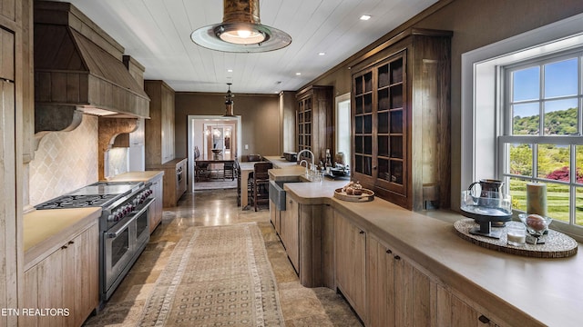 kitchen featuring range with two ovens, plenty of natural light, recessed lighting, and a sink